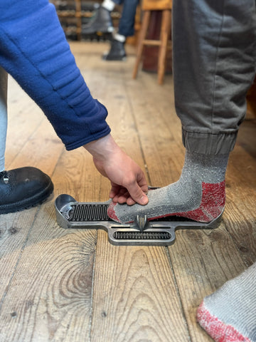 Limmer employee checking foot size on Brannock device.