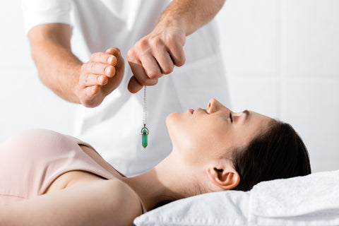 lady on couch with therapist with dowsing crystal