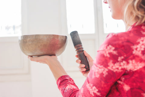 lady holding ibetan sound bowl