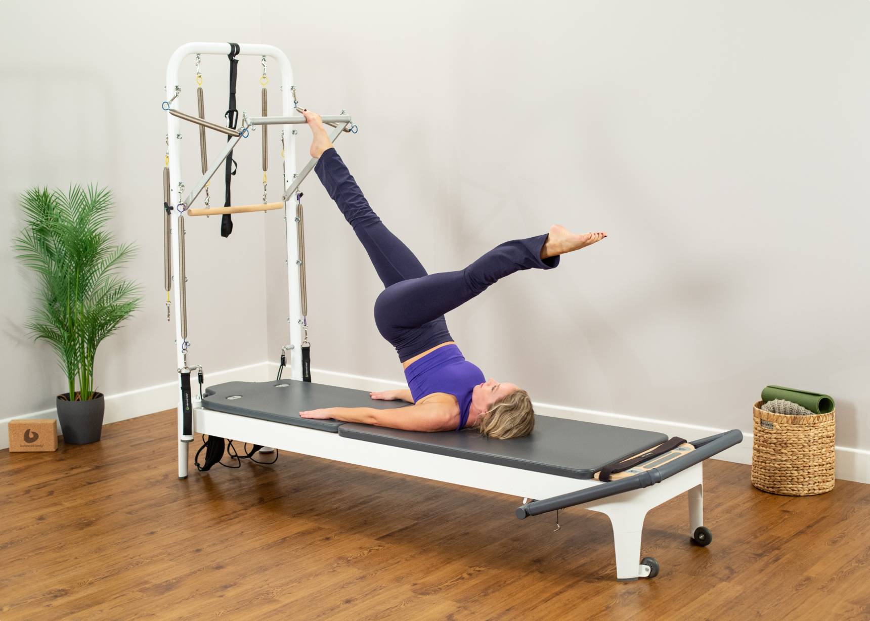 Woman targeting lower body while using the Allegro 2 Reformer Tower of Power.