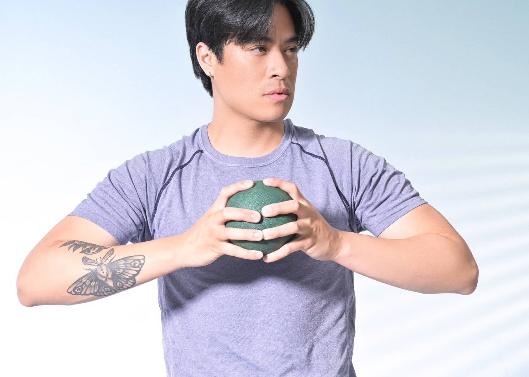 Man gripping green inflatable small exercise ball.