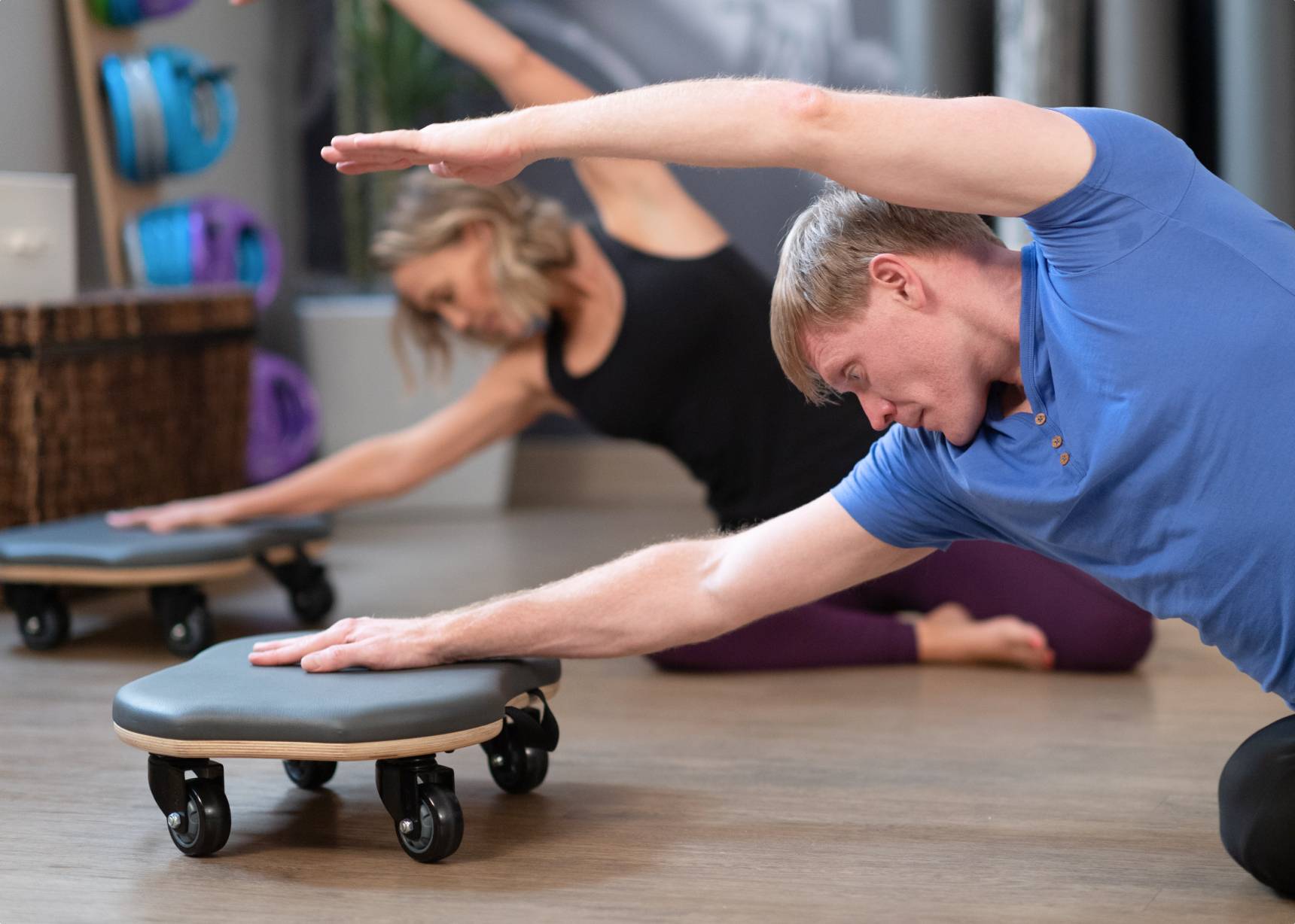 Couple stretching upper bodies on Orbit.