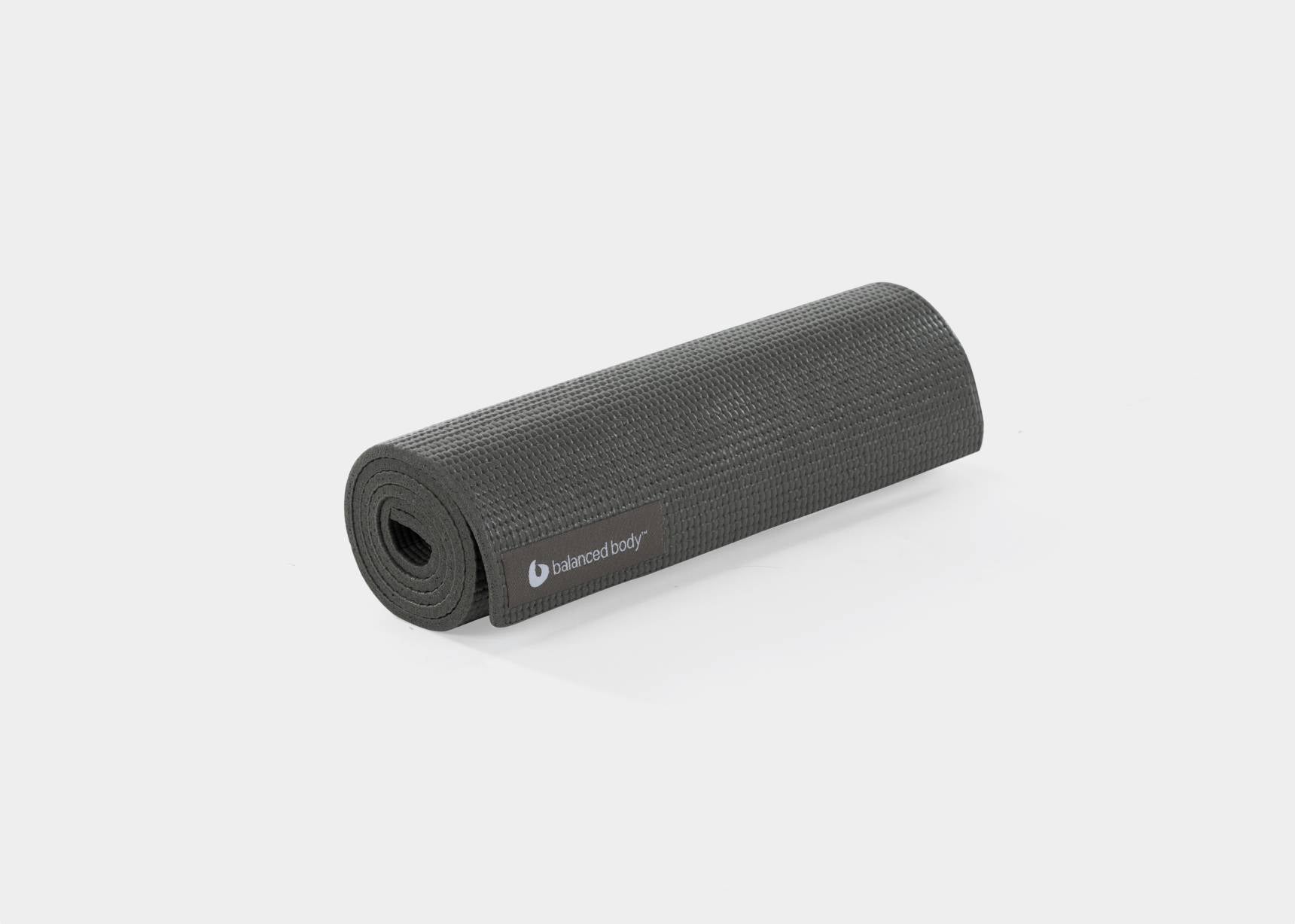 A rolled-up black mini mat for Pilates or yoga.