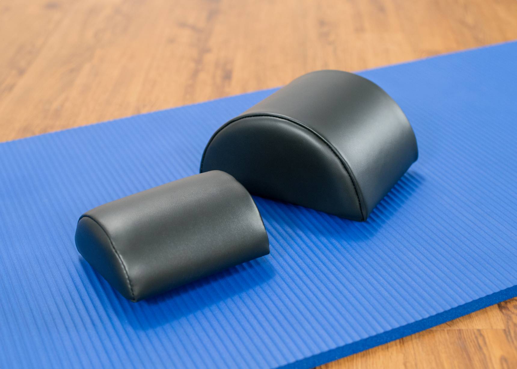 Small and large black half-cylinder cushions.