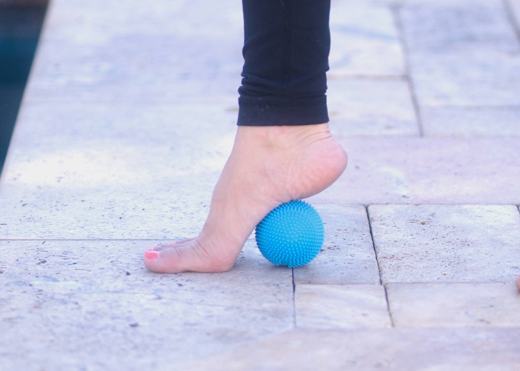 Person standing on Naboso Neuro Ball to release foot tension.