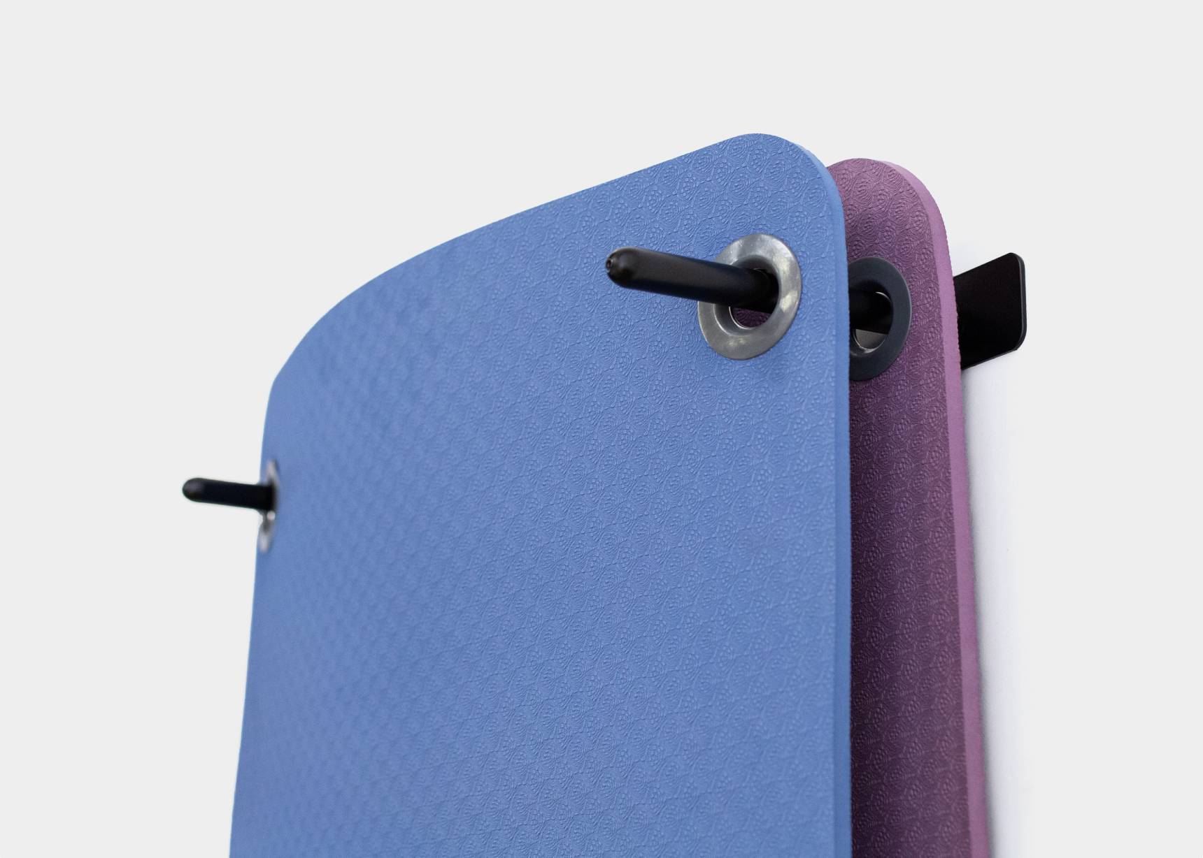 Hanging Pilates mats in shades of purple and blue.