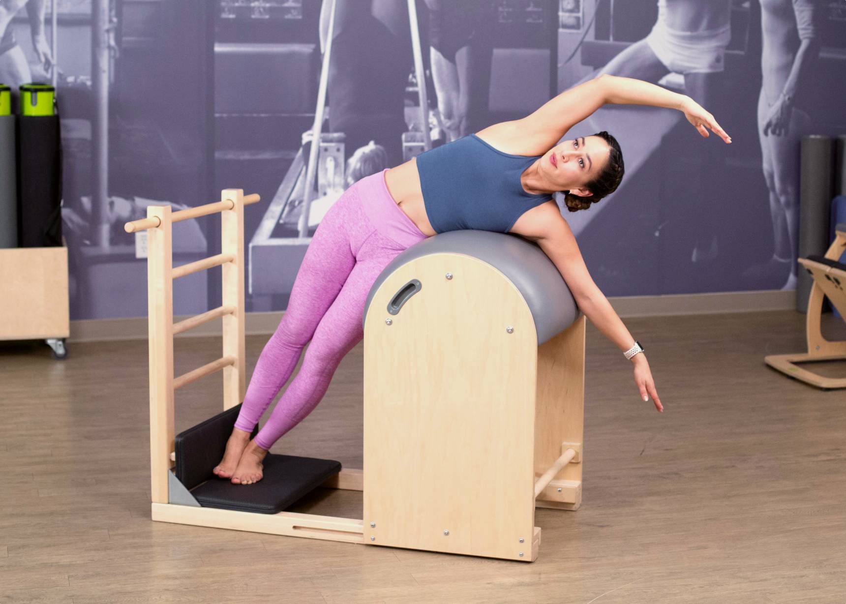 Balanced Body Ladder Barrel with Padded Foot Plates and Woman Doing Side Bend