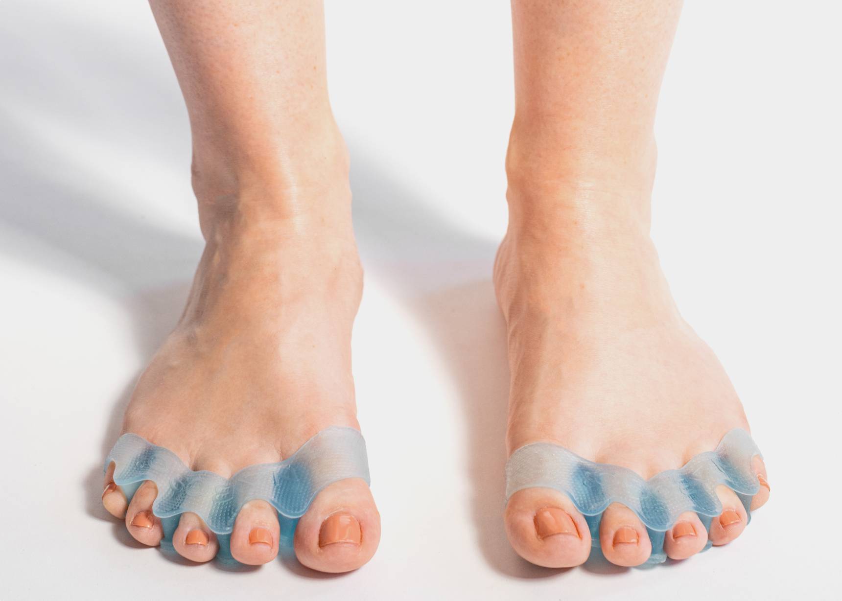 Close-up view of two legs with toes splayed, each featuring Naboso Splay technology for foot health.