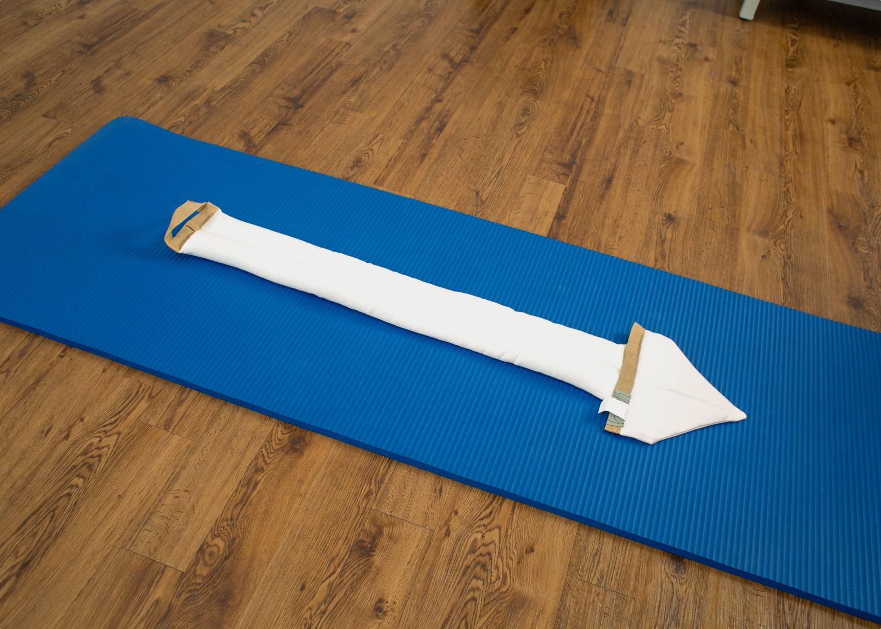 White SmartSpine cushion placed neatly on a blue exercise mat.