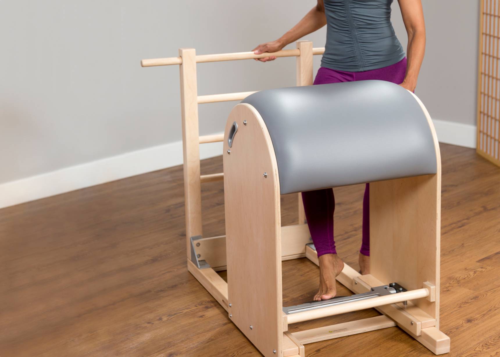 A profile view of a Pilates ladder barrel, highlighting its ergonomic design.