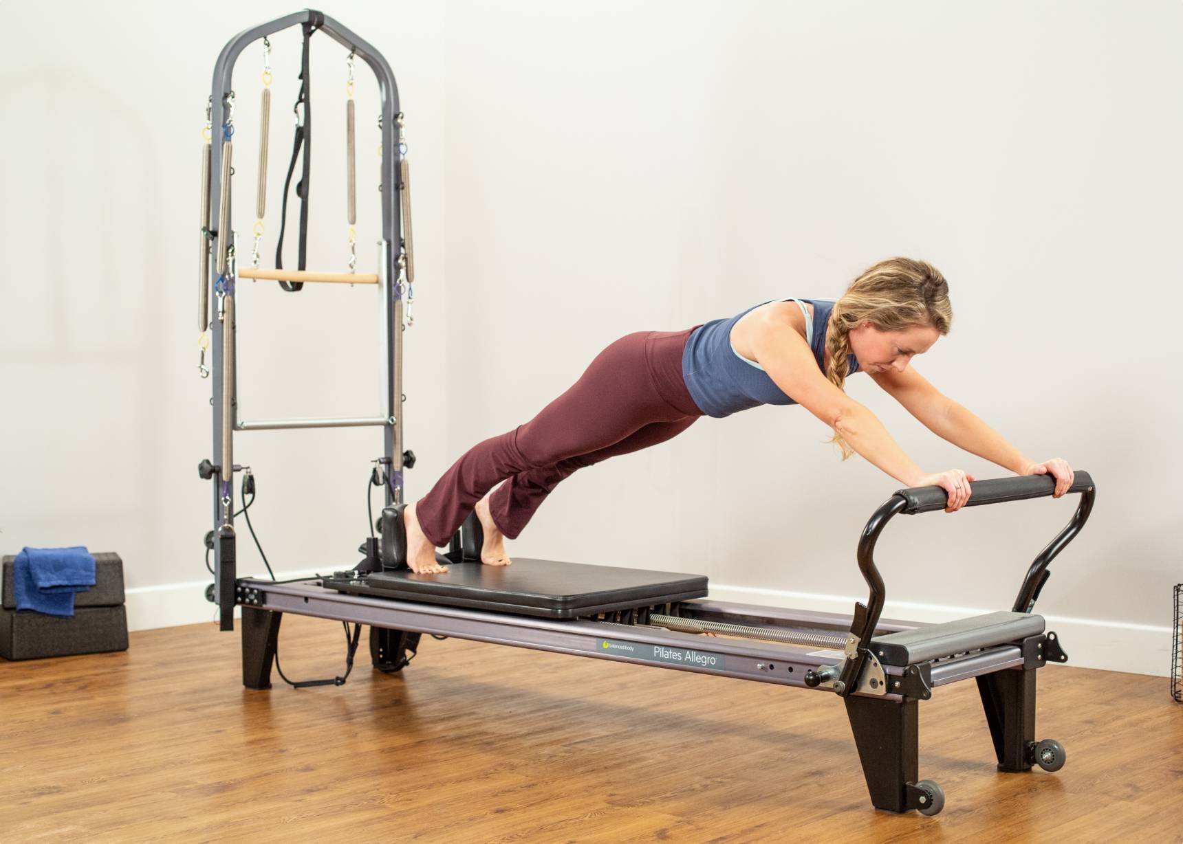 Woman working out with the Allegro Reformer Tower of Power and standing platform