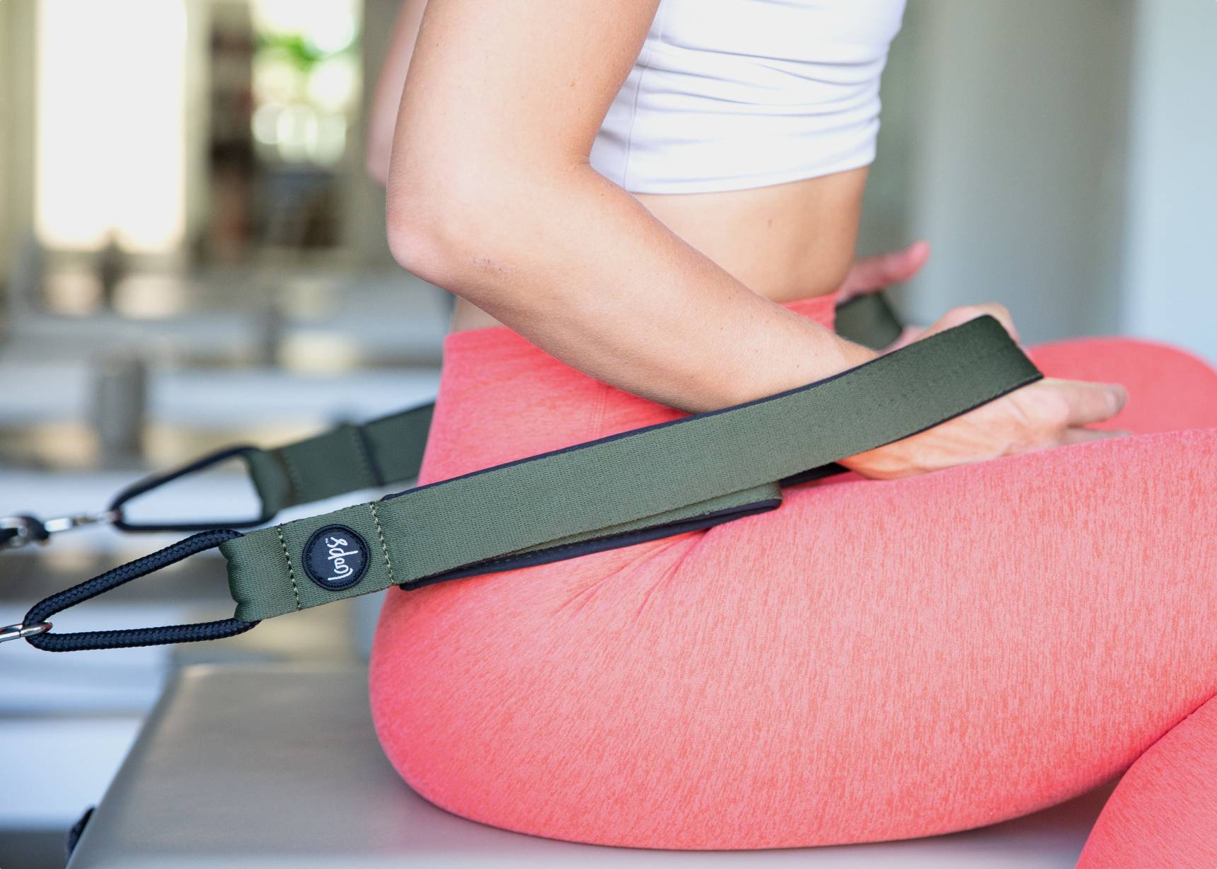 Woman pulling olive-colored Reformer Premium Loops.