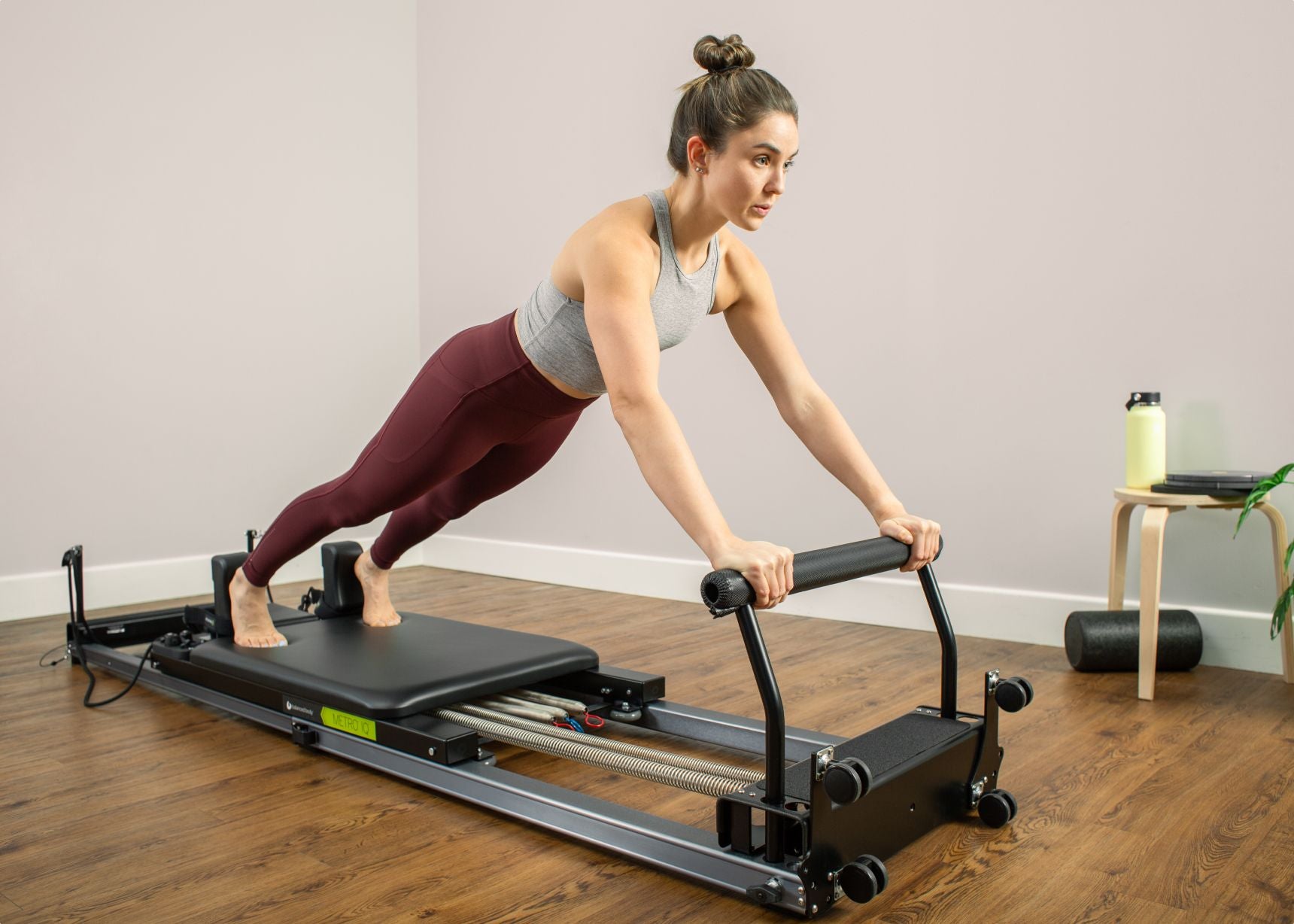 Woman using a Metro IQ Pilates Reformer.