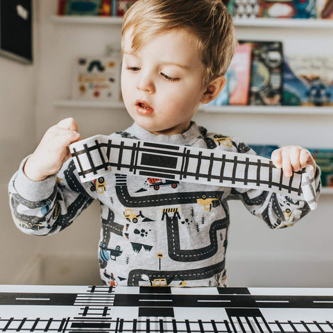 toddler unrolling train track tape