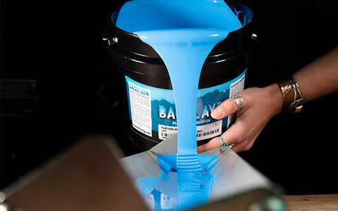 a bucket of baselayr plastisol emulsion pours into a scoop coater