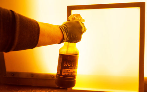 hand holding a bottle of emulsion prep in front of a screen