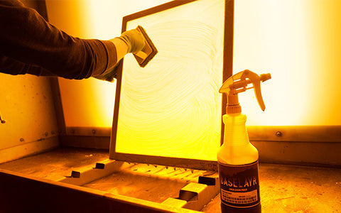 person scrubbing a screen in a washout booth