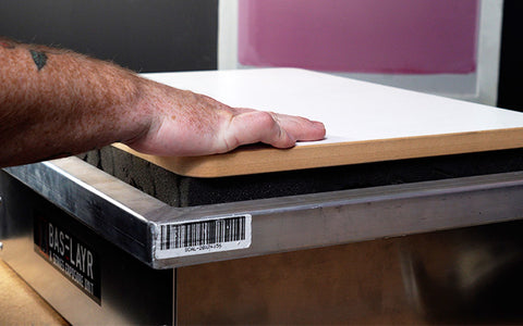 person placing wood on top of a screen on a compression exposure unit