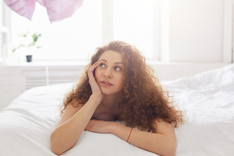 curly hair woman with frizzy, dry hair in cotton pillow case