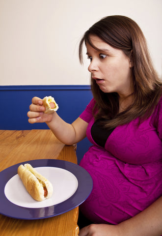 Femme enceinte mangeant du hot-dog pendant la grossesse