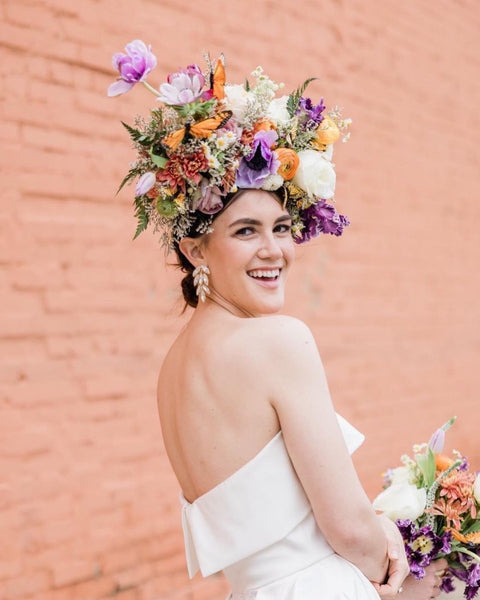 Smiling woman facing the camera with large floral headpiece