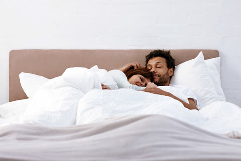 Couple cuddling in bed with buttery soft luxury bamboo rayon sheets 