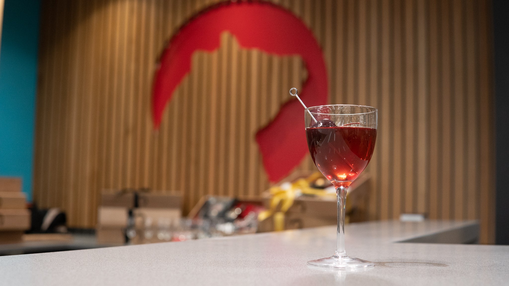 Manhattan cocktail with cherry garnish on a bar top 