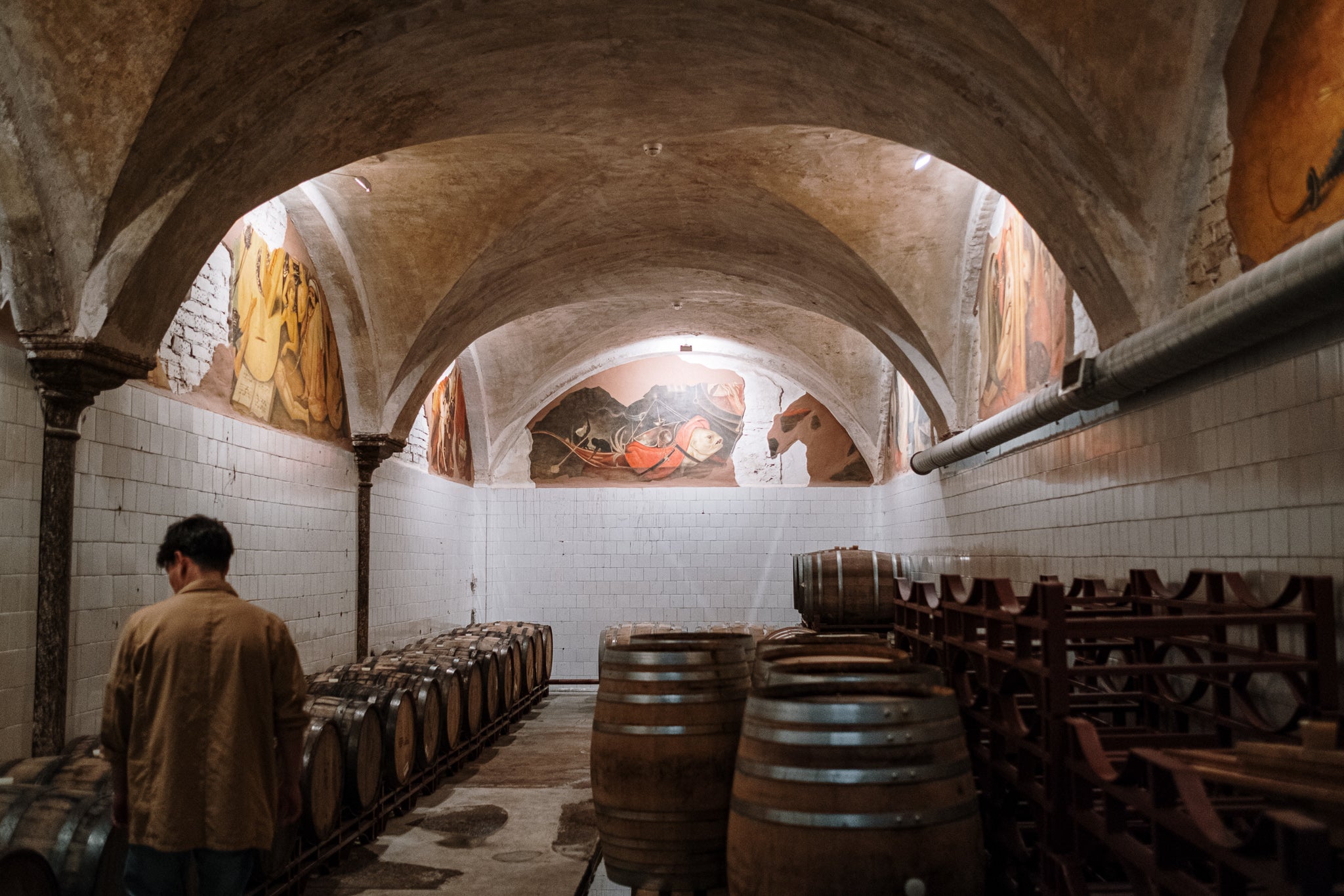 Sherry barrels in a cellar in Spain with a worked to the left side