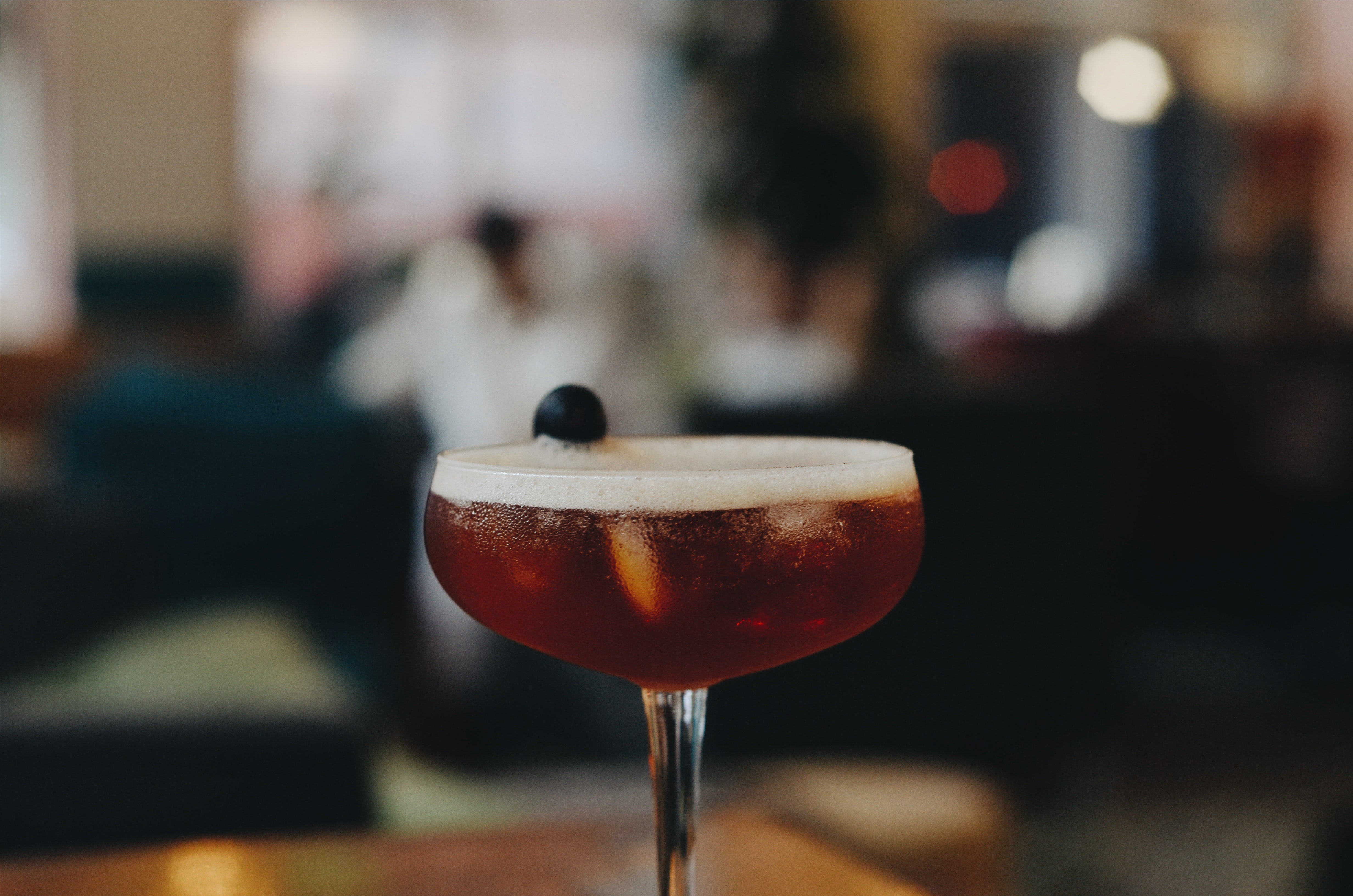 manhattan cocktail with a cherry garnish in a coupe glass