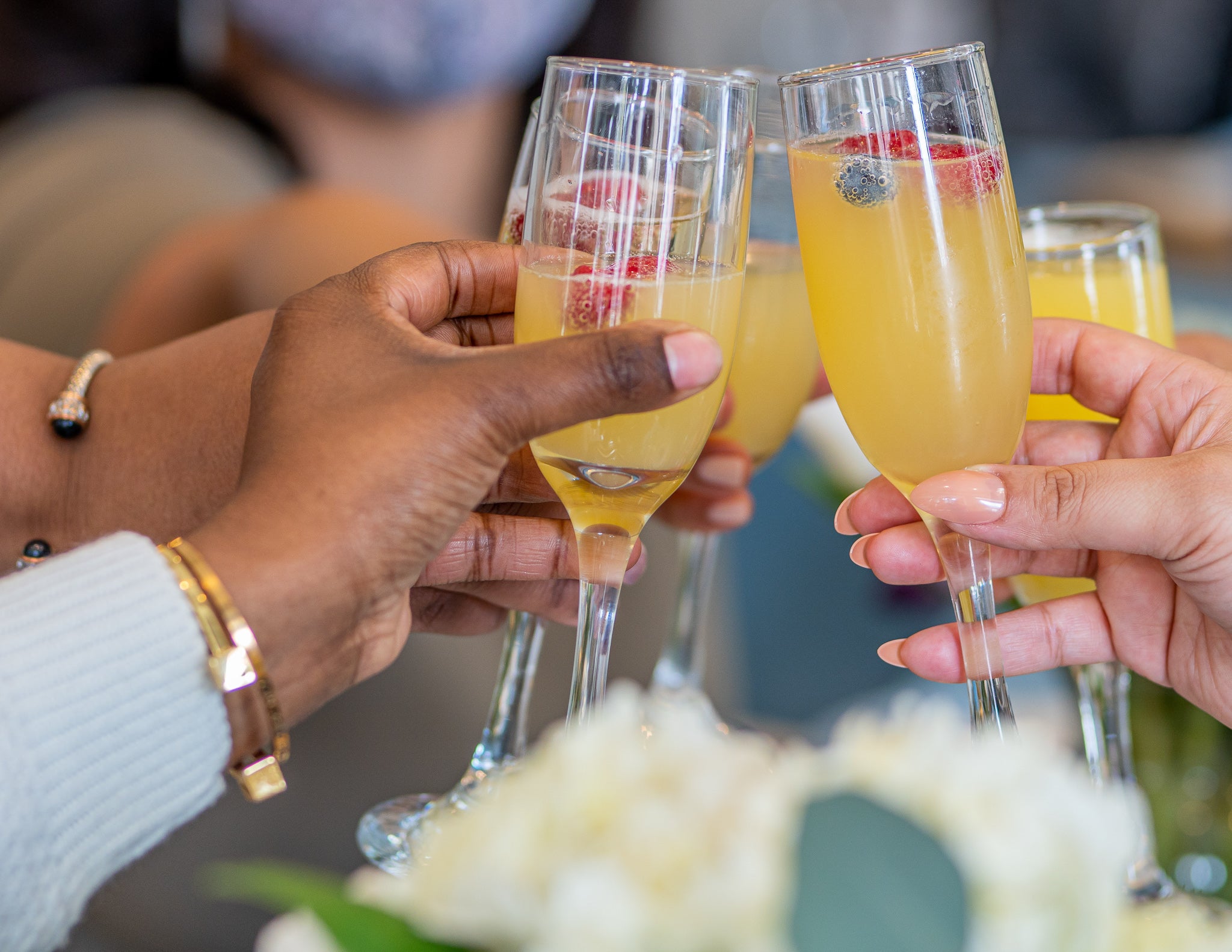 Cheers with mimosa's in flute glasses amongst friends