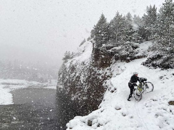 Ross O’Reilly pushing a bike in the snow