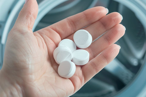 Person holding a handful of washing machine tablets