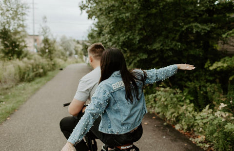 bride to be wearing personalized jacket with pearls during engagement shoot