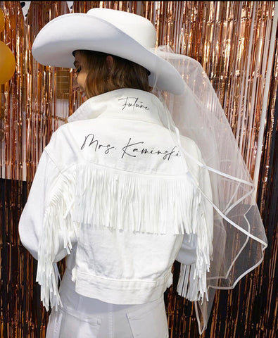Bride before a night out in her custom bridal denim jacket with white fringe.