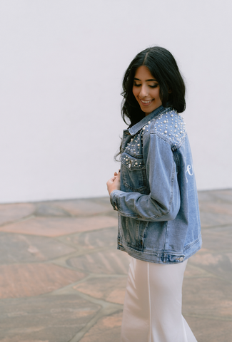 bride wearing her oversized denim jacket with wedding dress