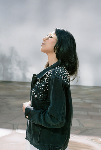 bride wearing black denim jacket with pearls