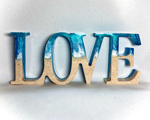 Love sign with honeymoon sand preserved inside 
