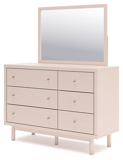 Twin Upholstered Panel Headboard by Wistenpine Accompanied by a Mirrored Dresser