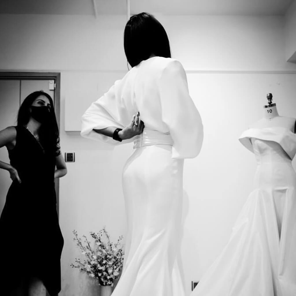 A bride trying on a Christina Devine wedding dress
