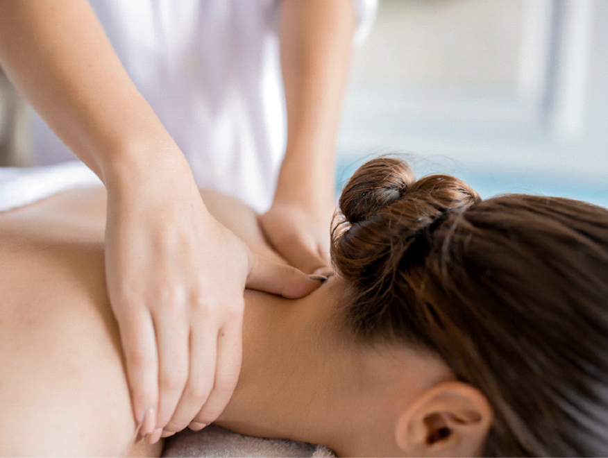 Des mains massant la nuque d’une femme portant les cheveux en chignon.