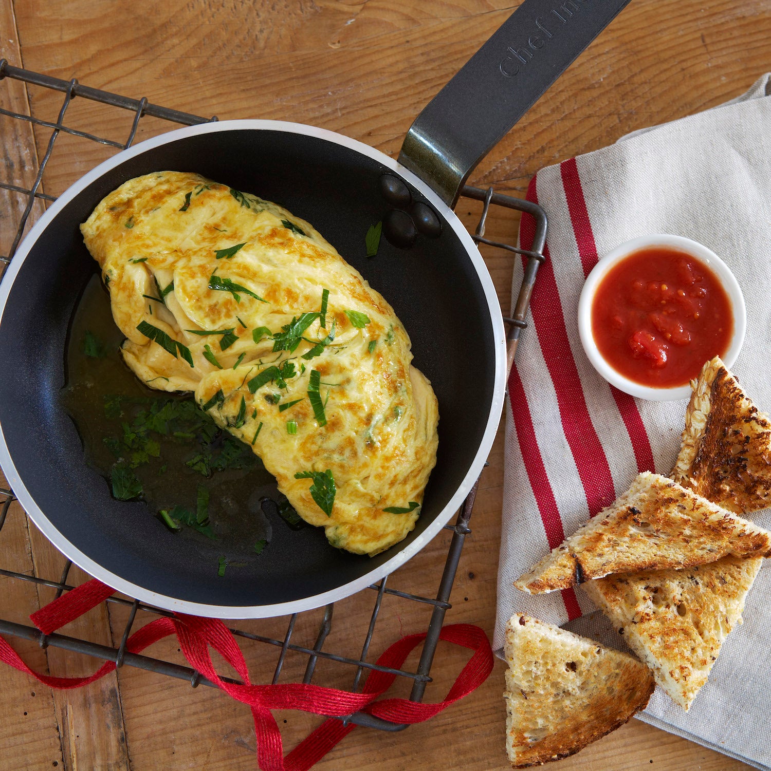 Omelette in a pan with toast and sauce