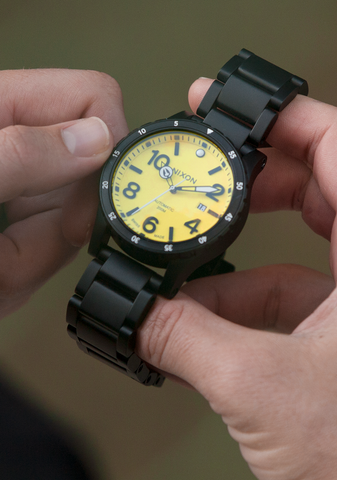 Man changes the time of the Nixon Diplomatic watch that doesn't need a battery.