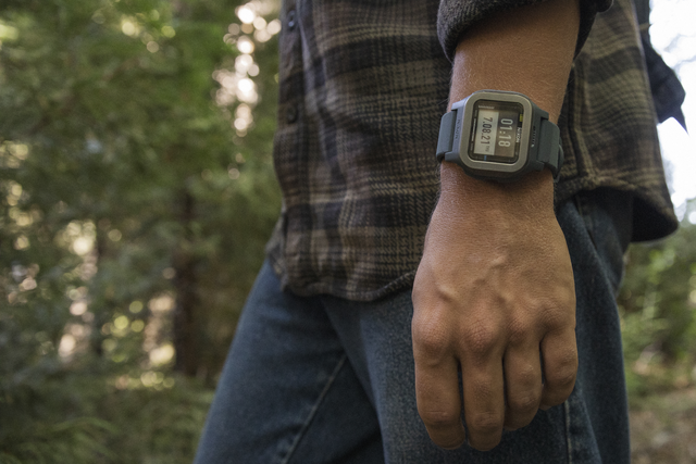 A man walks in the woods wearing a Nixon Regulus Expedition