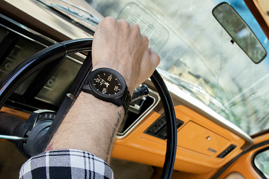 Man wearing a Nixon Corporal Field Watch while driving a car