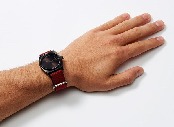 Man wearing a Nixon Time Teller with a red NATO strap