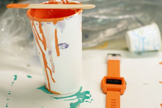 An orange Nixon Base Tide Pro next to a can of paint