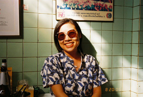 Photograph of person smiling sitting in sunlight