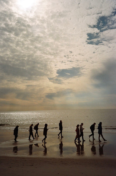Photograph of people walking on a beach