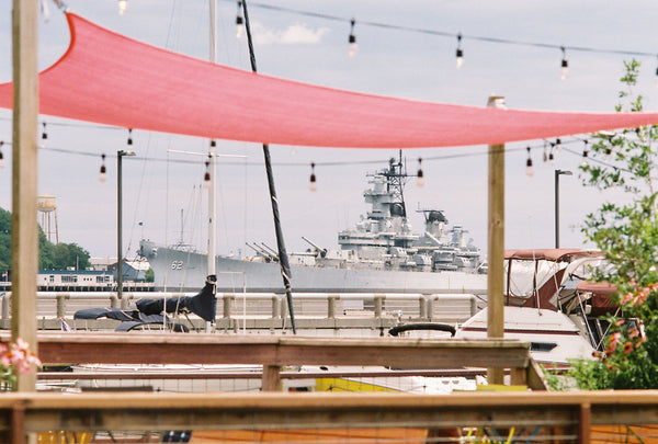 Photograph taken with a Konica Autoreflex TC of a outdoor restaurant and boat in the distance