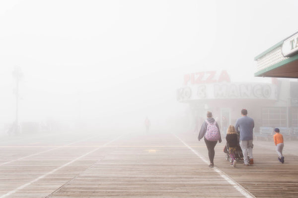 photograph of family walking on the ocean city boardwalk with fog